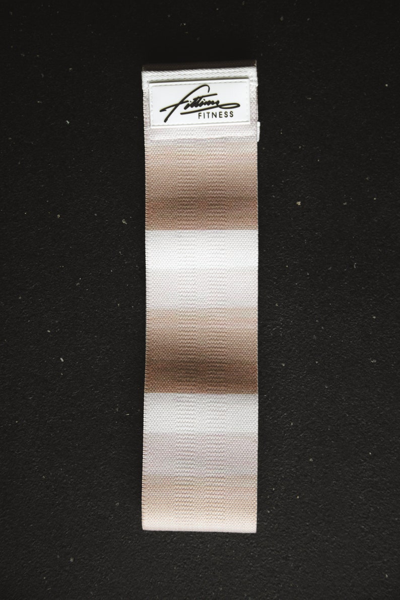 May include: A white and beige striped fabric resistance band with the text "Fitlife Fitness" on a white label.