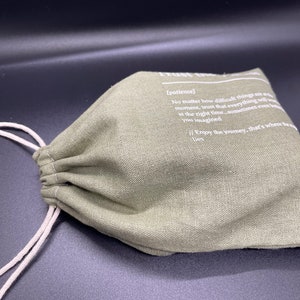 May include: A green drawstring bag with a white text quote that reads: "[patience] No matter how difficult things are at the moment, trust that everything will work out at the right time...sometimes even better than you imagined. Enjoy the journey, that's where the magic lies."