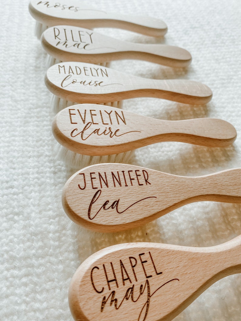 May include: Five wooden hairbrushes with engraved names, including Riley Mae, Madelyn Louise, Evelyn Claire, Jennifer Lea, and Chapel May.