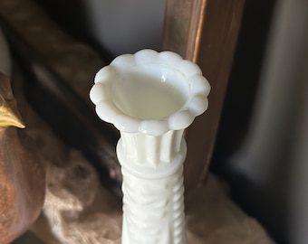 Op de afbeelding: Een witte melkglasvaas met een gegolfde rand en een textuurontwerp. De vaas is hoog en slank.