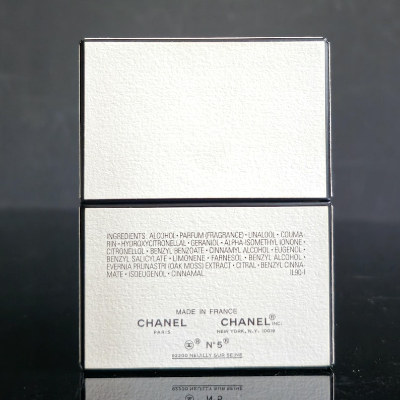 May include: A white rectangular box with black trim, featuring the Chanel logo and product information. The box includes a list of ingredients and the text "MADE IN FRANCE". The product is Chanel N&deg;5.