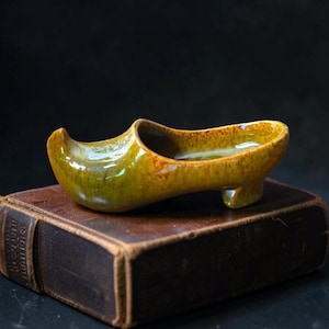 Mobiletto decorativo vintage in ceramica inglese con motivo a stivale e folletto, ideale per libreria e oggetti da collezione.