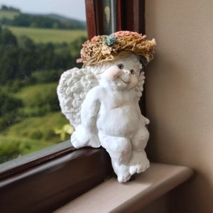 Bebé ángel querubín en la estantería