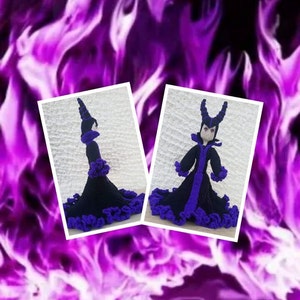 May include: A crocheted doll dressed in a black and purple gown with a pointed hat and horns. The doll is standing on a white background.