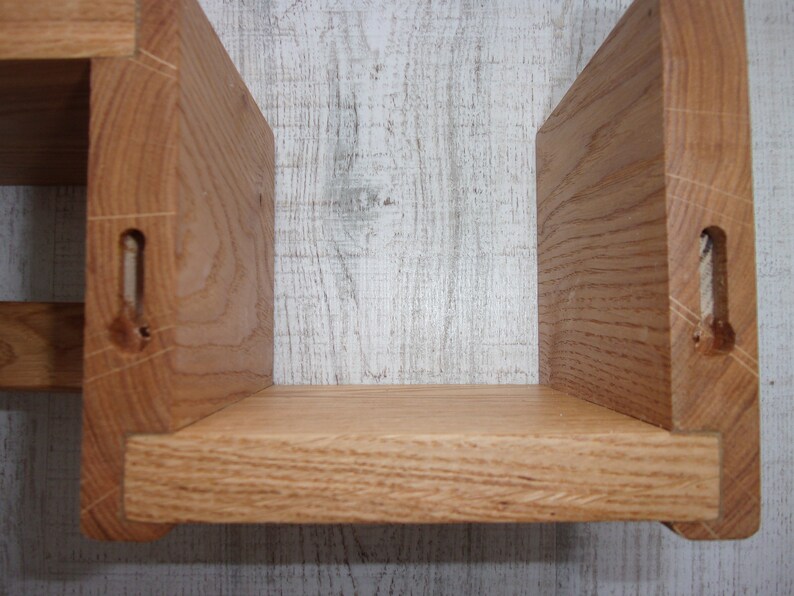 K&ouml;nnte beinhalten: Ein Holzregal mit zwei Regalbrettern. Die Regalbretter sind aus massivem Holz und haben eine nat&uuml;rliche Oberfl&auml;che. Das Regal ist f&uuml;r die Wandmontage konzipiert.