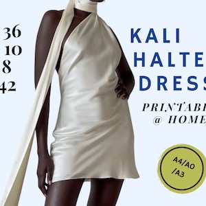 May include: A white halter dress with a long, flowing scarf. The dress is a simple, elegant design with a fitted bodice and a flowing skirt. The text "KALI HALTER DRESS PRINTABLE @ HOME A4/AO/A3" is printed on the image.