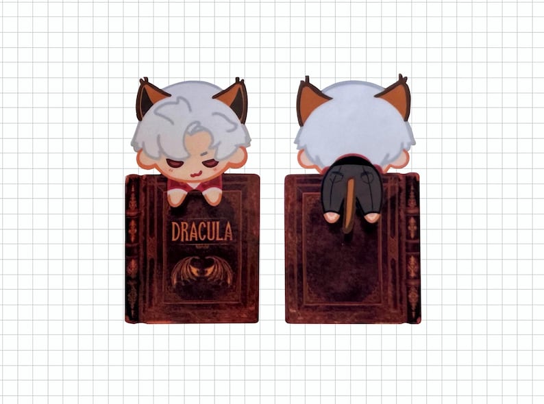 May include: A Dracula-themed bookmark featuring a cartoon character with white hair, brown ears, and a red shirt, perched on a book. The book is dark red with the title "DRACULA" and a bat illustration.