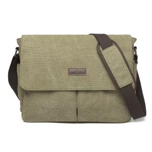 Pode incluir: Uma bolsa carteiro de lona verde-oliva com uma alça de ombro ajustável marrom-escura com uma seção acolchoada. A aba frontal exibe um emblema retangular marrom com o nome da marca BAGWISE em letras metálicas prateadas.