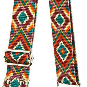 May include: A colorful patterned fabric strap with a geometric design in shades of red, orange, yellow, green, and purple. The strap has silver metal hardware and is attached to a green canvas bag.
