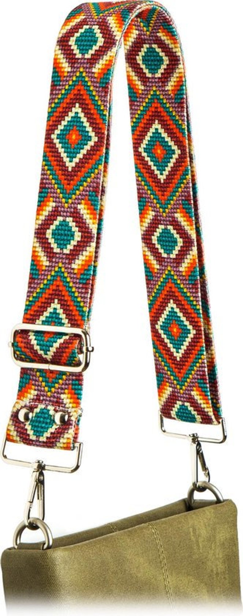 May include: A colorful patterned fabric strap with a geometric design in shades of red, orange, yellow, green, and purple. The strap has silver metal hardware and is attached to a green canvas bag.