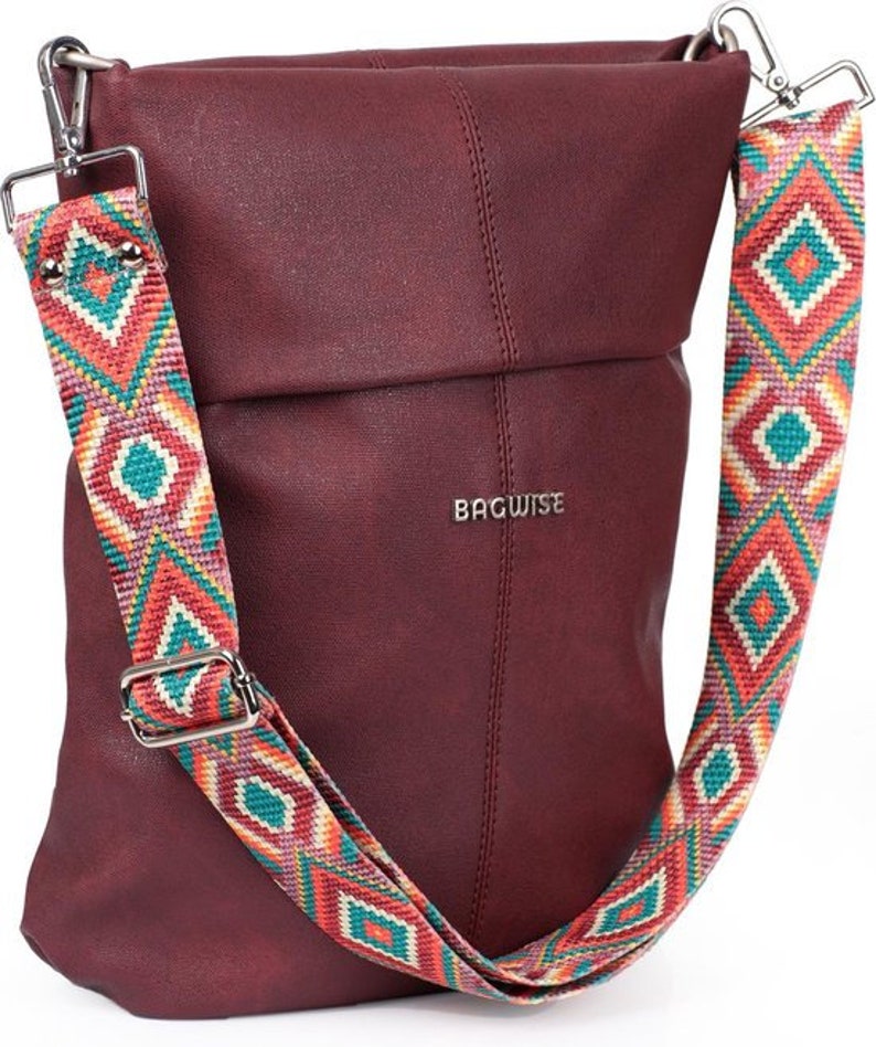 May include: A burgundy faux leather crossbody bag with a colorful geometric patterned strap. The strap is adjustable and has a silver buckle. The bag has a flap closure and the brand name "BAGWISE" is printed on the front.