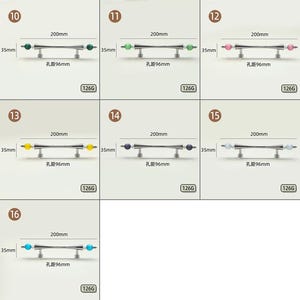 Pode incluir: Uma cole&ccedil;&atilde;o de sete puxadores de arm&aacute;rio em metal, cada um com uma barra central e detalhes esf&eacute;ricos em v&aacute;rias cores, incluindo verde, rosa, amarelo, roxo, branco e azul. Cada puxador mede 200mm de comprimento, 35mm de altura, com espa&ccedil;amento de 96mm entre furos.