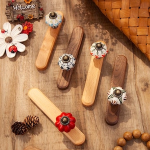 Op de afbeelding: Een witte keramische mok met een zwart handvat en de tekst "But First, Coffee" in een vetgedrukte, zwarte letter. De mok staat tegen een vage achtergrond, wat een gezellige setting suggereert.