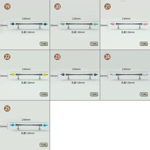 Pode incluir: Uma cole&ccedil;&atilde;o de sete puxadores de metal para arm&aacute;rios, cada um com uma barra central e extremidades esf&eacute;ricas em v&aacute;rias cores, incluindo verde, rosa, amarelo, azul e branco. Cada puxador mede 230mm de comprimento, 35mm de altura, com uma dist&acirc;ncia entre furos de 128mm.