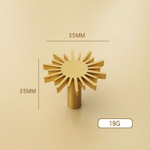 May include: Gold-toned metal cabinet knob with a sunburst design. The knob measures 35mm in diameter and weighs 19 grams.