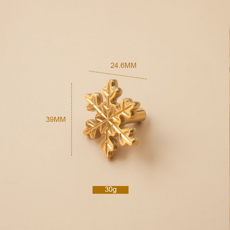 Op de afbeelding: Gouden kastknop in de vorm van een sneeuwvlok met een diameter van 39 mm en een hoogte van 24,6 mm. De knop weegt 30 g.
