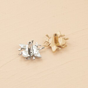 Peut inclure: Deux boutons de porte en forme d'abeille, l'un argent&eacute; et l'autre dor&eacute;. Les boutons sont vus du dessous, avec les trous de vis visibles.