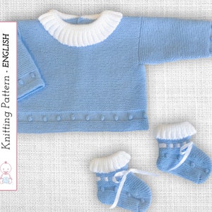 Puede incluir: Un jersey de punto azul claro para bebé con cuello blanco y botines a juego. El jersey tiene cierre de botón y los botines tienen ribete blanco y una cinta blanca.