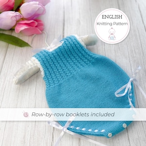 Puede incluir: Un pelele de bebé tejido en azul claro con lazos y botones de cinta blanca. El pelele se muestra en una percha blanca con un ribete de encaje blanco. La imagen incluye el texto "ENGLISH Knitting Pattern" y "Row-by-row booklets included".