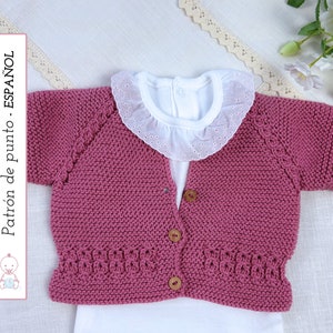 May include: A pink knitted baby cardigan with short sleeves and a button closure. The cardigan has a delicate stitch pattern around the neckline and sleeves. "Patrón de punto - ESPAÑOL" is written on the left side of the image.
