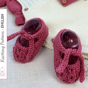 Puede incluir: Un par de botitas de bebé de punto rosa con un lazo en el tobillo. Las botitas están sobre un fondo de tejido blanco de punto. Patrón de tejido - INGLÉS