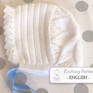Puede incluir: Gorrito de bebé de punto blanco con ribete de encaje y cinta azul. Patrón de tejido - INGLÉS -