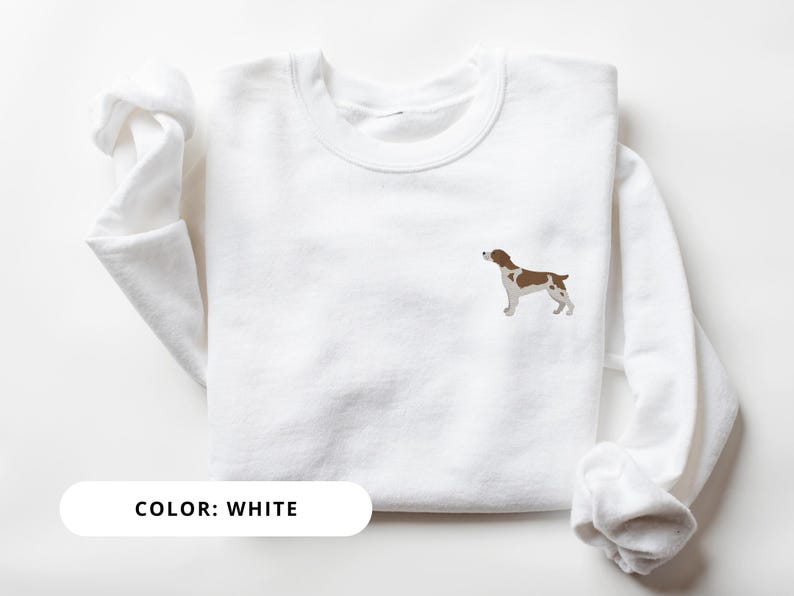 May include: White sweatshirt with a brown and white dog silhouette embroidered on the front. The text "COLOR: WHITE" is printed below the image.