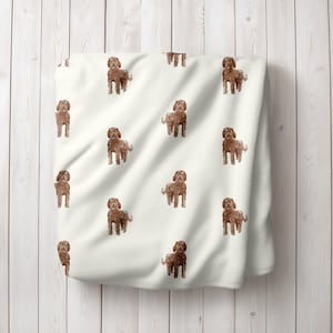 May include: White fleece blanket with a repeating pattern of brown dogs. The dogs are all facing forward and have their tongues sticking out.