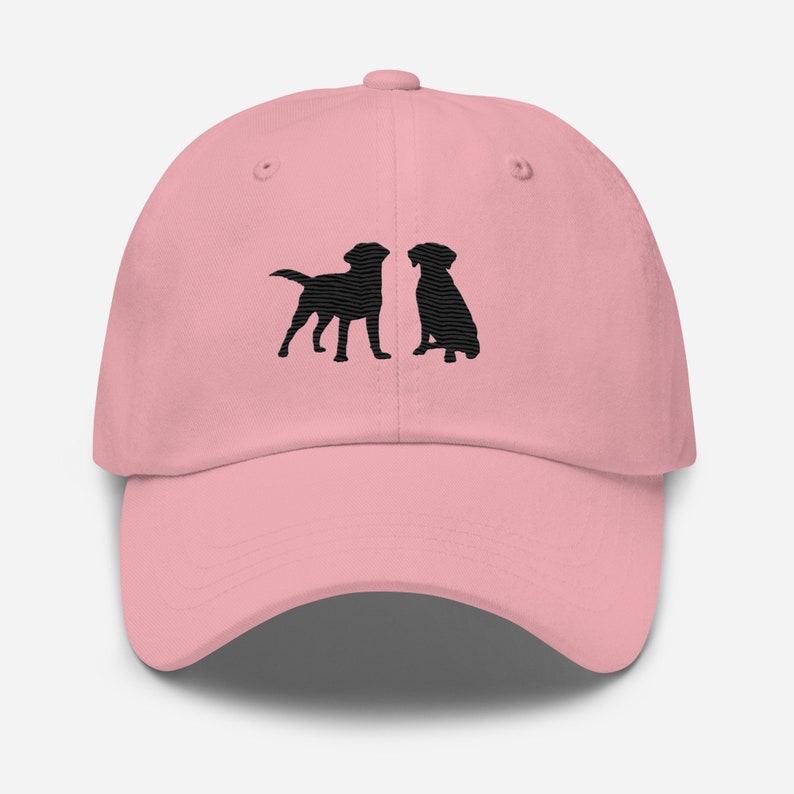 May include: A pink baseball cap with black embroidered silhouettes of two Labrador Retrievers facing each other.