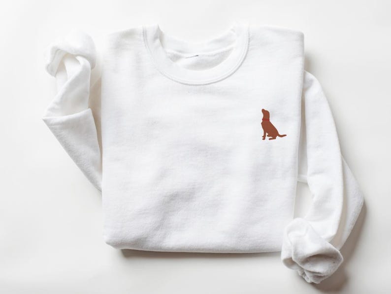 May include: White long-sleeved sweatshirt with a brown dog silhouette embroidered on the left chest.