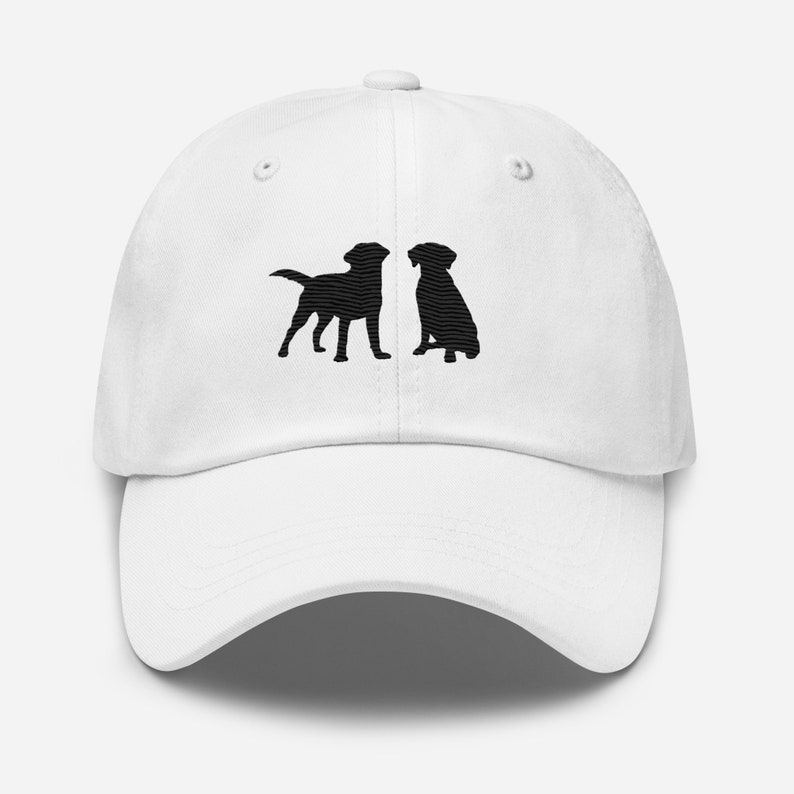 May include: White baseball cap with black embroidered silhouettes of two dogs facing each other.