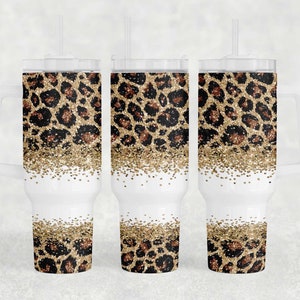 May include: Three stainless steel tumblers with lids and straws. The tumblers are decorated with a leopard print pattern with gold glitter accents.