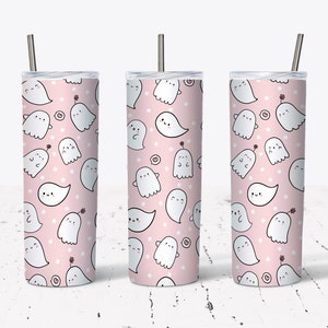 May include: Three pink stainless steel tumblers with a pattern of white ghosts and white dots. The tumblers have lids and straws.