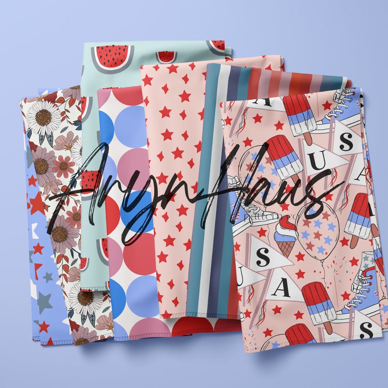May include: Several folded fabrics with diverse patterns, including red stars, blue and red stripes, watermelon slices, and floral designs. The fabrics display the text "Aryn Haus" across their surfaces.