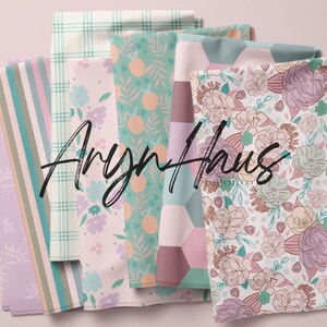 May include: A selection of patterned fabrics in diverse designs and colours. The fabrics feature floral, geometric, and striped patterns in shades of pink, green, and purple. The text "Aryn Haus pattern co" is displayed in a cursive font.