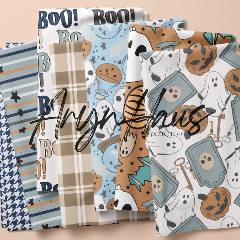 May include: A selection of Halloween-themed fabric patterns. Designs include "BOO!" text, plaid, stripes, stars, skulls, ghosts, pumpkins, and other spooky elements in various colours. The fabrics are folded and displayed.