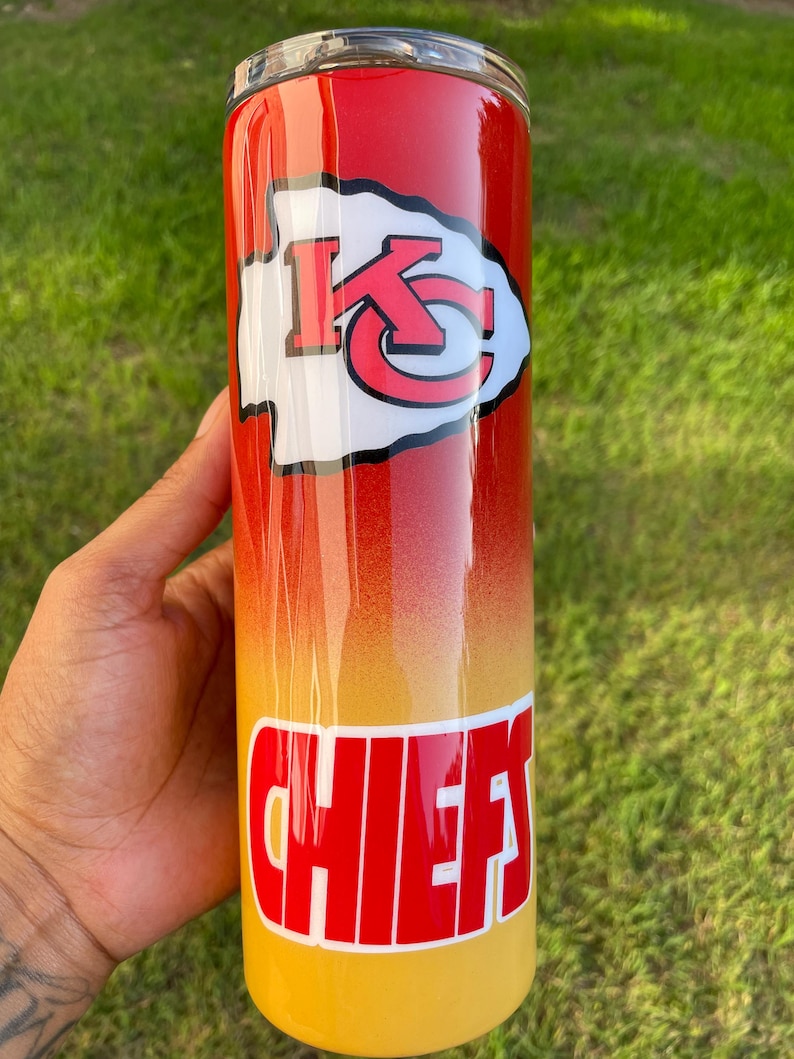May include: A stainless steel tumbler with a red, orange, and yellow gradient design. The tumbler features the Kansas City Chiefs logo and the word "CHIEFS" in red block letters.