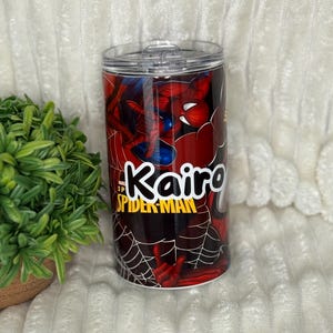 May include: A personalised tumbler with Spider-Man graphics. The tumbler is mainly red with a black spiderweb design and a blue and red Spider-Man illustration. The name "Kairo" is printed in white and yellow, with the words "Spider-Man" below.