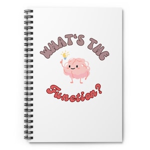 以下が含まれることがあります： 白い螺旋状のノートに、電球を持ったピンクの脳の漫画と、茶色と赤の文字で「What's the Function?」と書かれている