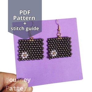 Pode incluir: Um par de brincos quadrados feitos de pequenas contas escuras, cada um com um pequeno desenho de flor no centro. Os brincos penduram de ganchos dourados. A imagem também inclui o texto "PDF Pattern + stitch guide".