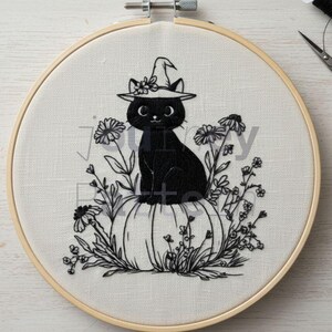 May include: An embroidery hoop featuring a black cat wearing a witch hat, perched atop a pumpkin. The cat is surrounded by floral embroidery. The design is in black thread on a cream-colored fabric, perfect for Halloween decor.