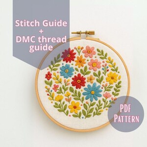 Pode incluir: Um bastidor de bordado floral com um design floral colorido em vermelho, amarelo, azul e rosa. O texto "Stitch Guide + DMC thread guide" é visível, juntamente com "PDF PATTERN". O bordado está num bastidor de madeira.