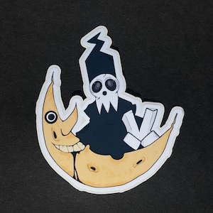 Puede incluir: Una pegatina con un personaje de dibujos animados con túnica y sombrero negros, con cara de calavera, sentado en una luna creciente amarilla. La luna tiene una cara sonriente, sobre un fondo negro.