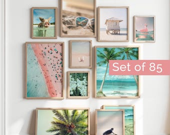 Könnte beinhalten: Ein Set aus 85 gerahmten Kunstdrucken für eine Bilderwand mit verschiedenen Küsten- und Tropenmotiven, darunter ein Schwein im Wasser, eine Sonnenbrille im Sand, eine Strandhütte, ein Flamingo, ein rosa Strand, Surfbretter, Kakteen und Palmen.