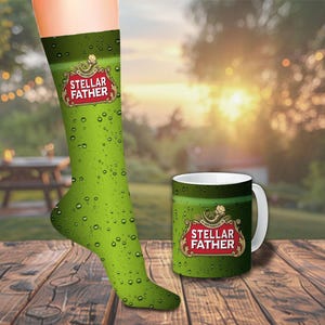 Könnte beinhalten: Grüne Socken und eine passende Tasse mit dem Text "STELLAR FATHER" in einem roten und goldenen Emblem. Die Socken sind an einem Fuß, und die Tasse steht auf einer Holzoberfläche. Der Hintergrund ist eine verschwommene Szene im Freien.