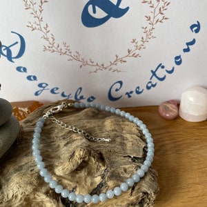 Può includere: Un braccialetto per caviglia con perline di pietra azzurra, con chiusura e catena di estensione in argento.