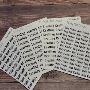May include: Three sheets of white sticker paper with black text. The first sheet has the text "Raid Night" repeated multiple times. The second sheet has the text "Leveling" repeated multiple times. The third sheet has the text "Duty Finder" repeated multiple times.