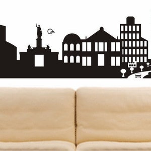 May include: Black and white silhouette of the city skyline of Nicosia, Cyprus. The skyline includes a church, a statue, and several buildings. The text "NIKOSIA" is at the bottom of the image.