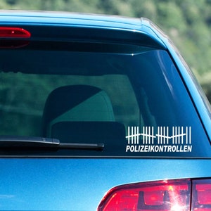 Könnte beinhalten: Ein weißer Vinyl-Aufkleber mit einem Zählmarken-Design und dem Text "POLIZEIKONTROLLEN" auf einem blauen Auto.