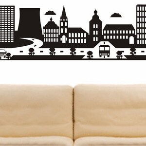 May include: Black and white silhouette of a city skyline with buildings, a road, trees, and a bus. The text "HÜRTH" is at the bottom of the image.